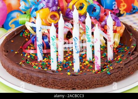 Geburtstag Chocolate Brownie Kuchen mit acht nicht leuchtende Kerzen mit den Worten Happy Birthday auf die Kerzen gedruckt. Stockfoto