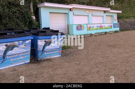 Außerhalb der Saison Cafe auf New Quay [Ceredigion Wales} Strand geschlossen. Vier große Müll und Recycling Bins mit dem Ceredigion Delphin logo Stockfoto