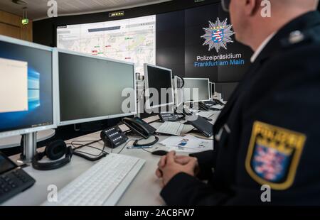 02 Dezember 2019, Hessen, Frankfurt/Main: Ein Polizist sitzt an einer Presse Termin in der neuen post-Befehl im Polizeipräsidium auf die Monitore. Der hessische Innenminister wollte eine Vorstellung von der Effizienz einer neuen operationellen System-Befehl zu erhalten. Die Software ermöglicht die Polizeieinsätze und Situationen schnell und umfassend zu erfassen. Foto: Frank Rumpenhorst/dpa Stockfoto