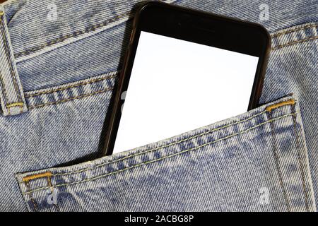 Verspotten Sie das Telefon mit weißem Bildschirm, das aus der Tasche der hellblauen Jeans pirschen kann. Vorlage verspott. Denim-Struktur. Gelegentliche Nutzung mobiler Inhalte. Kopierbereich Stockfoto