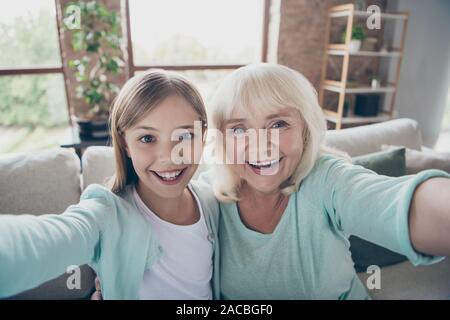 Closeup Foto von zwei Menschen weiß behaarte Oma kleine Enkelin selfies Video Skype Sommer Wochenende zusammen, Haus im Innenbereich Stockfoto