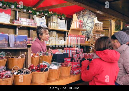 Weihnachten Marktstand verkaufen London bild Souvenirs in Trafalgar Square, mit dem Verkäufer und zwei Touristen auf der Suche nach Ware. London, UK, Stockfoto