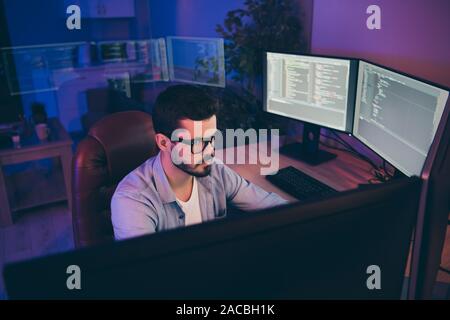 Foto von IT-Spezialist Kerl sitzen bequemen Stuhl suchen viele Monitore Test website Algorithmen ernsthafte Inhalte Entwicklung Experte dunkle Nacht Büro Stockfoto