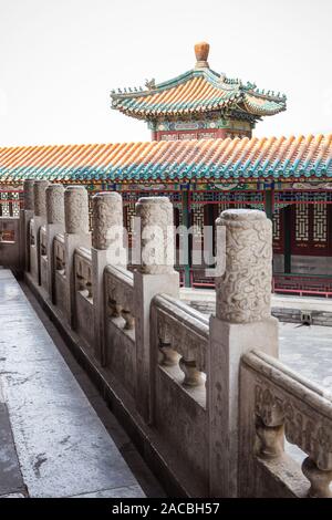 Stein Skulpturen stehen auf dem Zaun. Auf dem Hintergrund, von dem Sie den Turm im chinesischen Stil sehen kann, sowie das Dach der grün-orange Farbe. Stockfoto