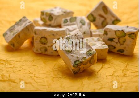 Osten Arabisch nougat Süße mit Pistazien auf gelbes Papier Hintergrund. Nahaufnahme Stockfoto