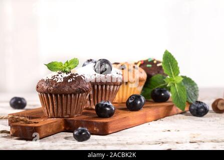 Blueberry und Schokolade Muffins auf weißem Holz- Hintergrund. Stockfoto