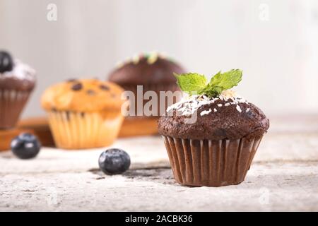 Blueberry und Schokolade Muffins auf weißem Holz- Hintergrund. Stockfoto
