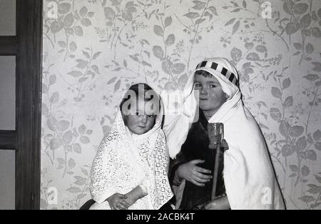 1950, historische, Weihnachten und zwei kleinen Kindern in Krippen Kostüme wie Josef und Maria, die Eltern von Jesus, England, UK gekleidet. Stockfoto