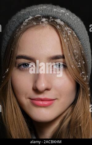 Nahaufnahme Portrait von blue-eyed Mädchen mit Schnee im Haar Stockfoto