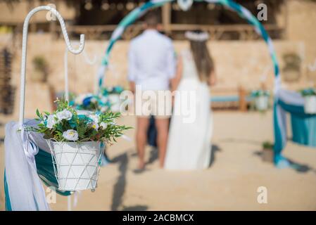 Setup von Hochzeit ehe Paar Zeremonie Gang mit Vorhängen und Bogen auf sandigen tropischen Strand Paradies Stockfoto