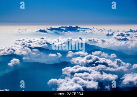 Luftaufnahme auf ein Gebirge von Wolken aus einem Flugzeug abgedeckt Stockfoto