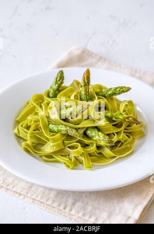 Portion Spinat Bandnudeln mit gebratenem Spargel Stockfoto