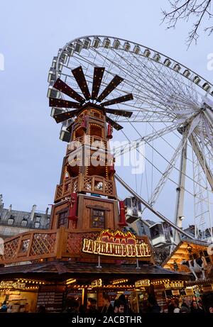 PARIS, Frankreich, 30. NOVEMBER 2019: riesige hölzerne Turm und ein großes Rad in den Hintergrund in den Weihnachtsmarkt auf den Jardin des Tuileries in Paris. Stockfoto