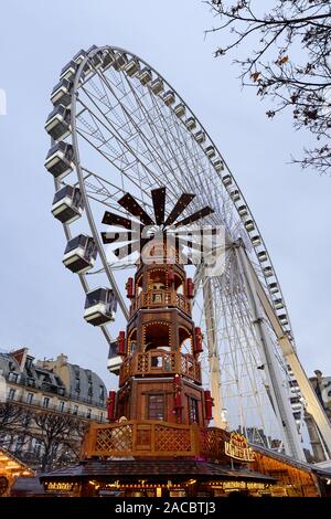 PARIS, Frankreich, 30. NOVEMBER 2019: riesige hölzerne Turm und ein großes Rad in den Hintergrund in den Weihnachtsmarkt auf den Jardin des Tuileries in Paris. Stockfoto