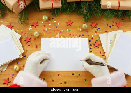 Santa Claus Weihnachten schreiben Buchstaben oder Wunschliste um Geschenkboxen, Weihnachtsbaum und viele Umschläge. Mockup leer. Weihnachtsgrüße Stockfoto