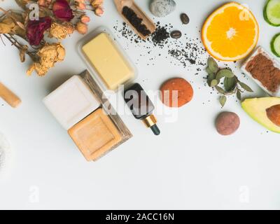 Self Care Produkten aus natürlichen Zutaten aus biologischem Anbau. Die moderne Medizin, Apotheke. Butters, Seife, Serum, schrubben, Orangenscheiben, Avocado, Steine für Stockfoto