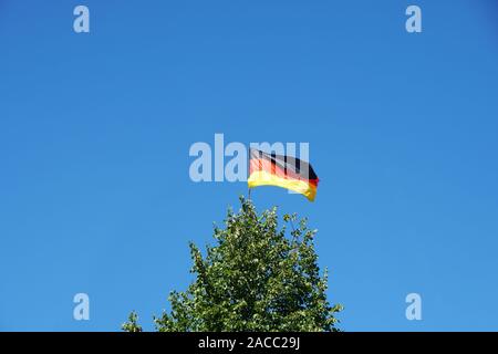 Deutsche Fahne schwenkten auf Baum gegen den klaren Himmel Hintergrund mit Kopie Raum, Deutschland Stockfoto