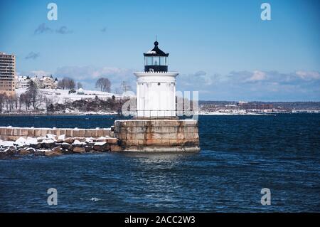 Die schneebedeckten Wahrzeichen breakwater Leuchtturm oder Bug Licht in South Portland auf einem sonnigen blauen Himmel Winter in Maine. Stockfoto