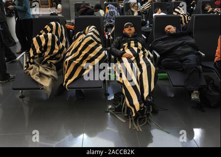 04.01.2014, Abu Dhabi, Vereinigte Arabische Emirate - schlafende Passagiere warten auf ihren Anschlussflügen in der transithalle während einer Zwischenlandung. Stockfoto