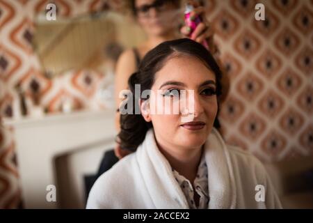 Eine hübsche, schöne Frauen fertig wird, eine Braut für den Tag zu sein, ihre Haare, Make-up und Kleidung, die alle in der hochzeitssuite Vorbereitung abgeschlossen, Bridal prep Stockfoto