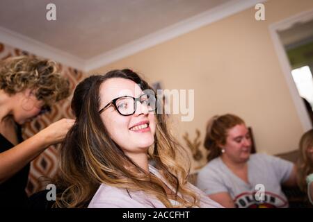 Eine hübsche, schöne Frauen fertig wird, eine Braut für den Tag zu sein, ihre Haare, Make-up und Kleidung, die alle in der hochzeitssuite Vorbereitung abgeschlossen, Bridal prep Stockfoto