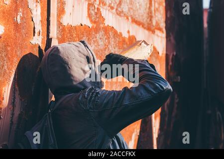 Obdachlose Alkoholiker Alkohol neben alten Bahnhof wagen, betrunkener Mann mit Kapuze in Alkoholismus Konzept, selektiver Fokus Stockfoto