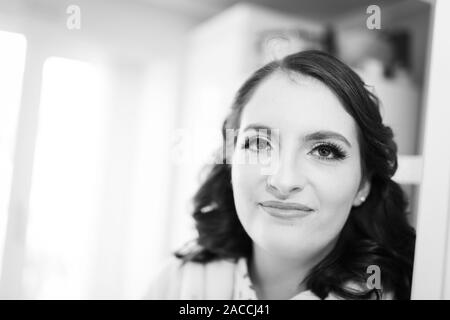 Eine hübsche, schöne Frauen fertig wird, eine Braut für den Tag zu sein, ihre Haare, Make-up und Kleidung, die alle in der hochzeitssuite Vorbereitung abgeschlossen, Bridal prep Stockfoto