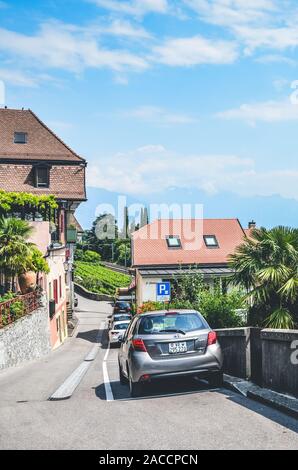 St. Saphorin, Schweiz - Juli 9, 2019: Straße in ländlichen Weinbereitung Dorf St. Saphorin in Schweizer Weinregion Lavaux. Häuser am Hang oberhalb der wunderschönen Genfer See. Natürliche Landschaft. Stockfoto