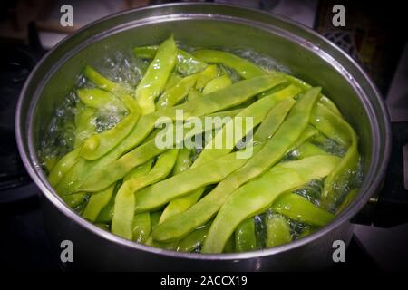 Der große Metallwanne mit kochendem Green Bean Pods innerhalb Stockfoto