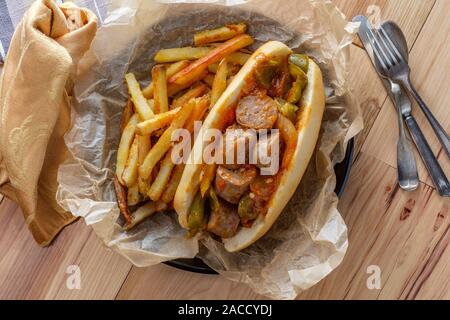 Gebratene wurst Zwiebeln und rote grüne und gelbe Paprika auf Sandwich bun Stockfoto