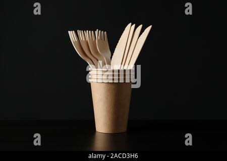 Eco-friendly Cups mit Gabeln und Messer auf schwarzem Hintergrund, Platz für Text Stockfoto