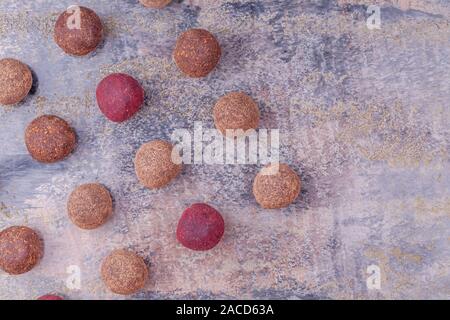 Hausgemachte Raw Vegan Cacao Energie Kugeln liegen auf einer Linie auf grauem Marmor Hintergrund Stockfoto
