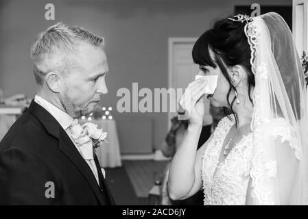 Eine Braut weint, während sie drinnen bei einer traditionellen englischen Hochzeitszeremonie im Manor, B&B, Hotel in Cheadle Stoke in Trent Staffordshire heiratet Stockfoto