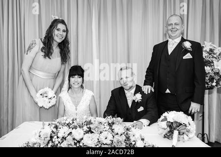 Ein Paar heiratet drinnen in einer traditionellen englischen Hochzeitszeremonie im Manor, B&B, Hotel in Cheadle, Stoke on Trent, Staffordshire Stockfoto