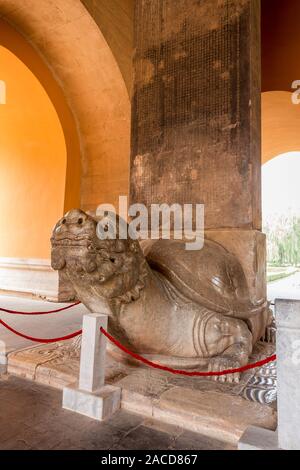 Skulptur einer Schildkröte hinter einem roten Fechten im Innenbereich. Stockfoto