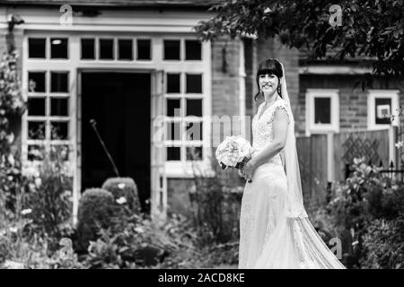 Eine Braut posiert für sie nach den Bildern der Zeremonie in den Gärten des Manor Hotels, B&B in Cheadle, Stoke on Trent, Staffordshire, Hochzeitstag Stockfoto