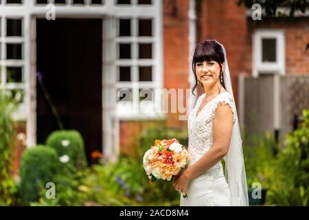 Eine Braut posiert für sie nach den Bildern der Zeremonie in den Gärten des Manor Hotels, B&B in Cheadle, Stoke on Trent, Staffordshire, Hochzeitstag Stockfoto