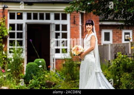 Eine Braut posiert für sie nach den Bildern der Zeremonie in den Gärten des Manor Hotels, B&B in Cheadle, Stoke on Trent, Staffordshire, Hochzeitstag Stockfoto