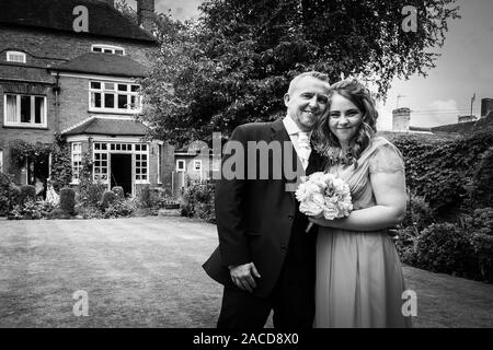 Braut, Bräutigam und Hochzeitsgäste posieren draußen für ein Foto im Manor Hotel, B&B in Cheadle, Stoke on Trent, Staffordshire, Hochzeitstag Stockfoto