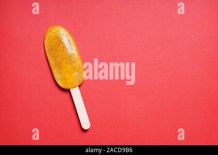 Passionsfrucht oder Maracuja popsicle oder Eis am Stiel oder Eis pop auf rotem Hintergrund mit Kopie Raum Stockfoto