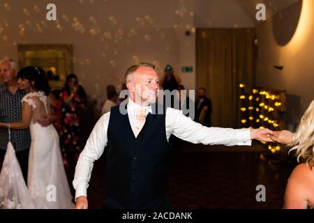 Die Leute tanzen und genießen sich bei einem Hochzeitsempfang, nach der Party im Manor Hotel and Guest House, Cheadle, Hochzeitsort der 2. Klasse Stockfoto