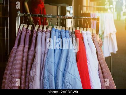 Wäscheständer mit dob Frühling Fashion Jacken aufhängen außerhalb Store - trendige Filter mit Sun flare Licht Leck Stockfoto