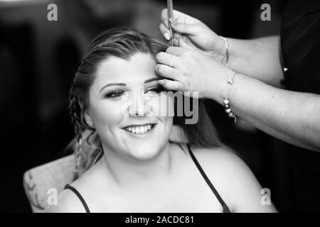 Eine wunderschöne Braut erhalten für Ihren besonderen Tag bereit, Vorbereitung in Haare und Make-up in der Vorbereitung für die Trauung durchgeführt Stockfoto