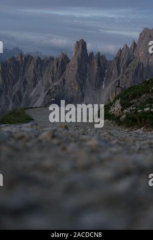 Nahaufnahme von einem Feldweg in den Dolomiten, im Hintergrund massiver Gipfel, Italien Stockfoto