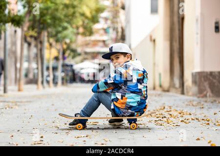 Süßes kleines Kind saß auf seinem sakteboard Stockfoto