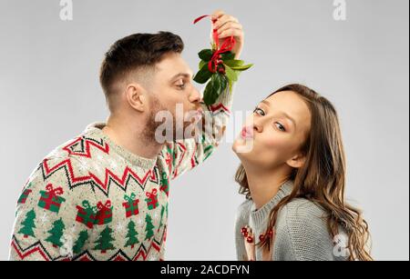 Glückliches Paar unter dem Mistelzweig küssen Stockfoto