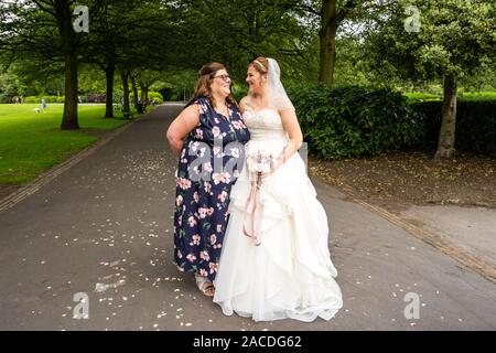 Braut und Brautjungfern haben Hochzeitsfotos in Floral Hall, Tunstall Park, Stoke on Trent, Hochzeitsfotos, Feiern, traditionelle englische Hochzeit Stockfoto