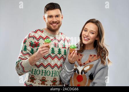Paar mit Cupcakes in hässlichen Weihnachten Pullover Stockfoto