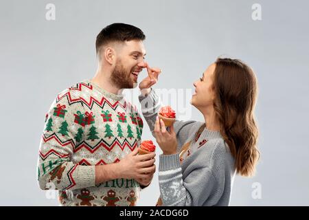 Paar mit Cupcakes in hässlichen Weihnachten Pullover Stockfoto