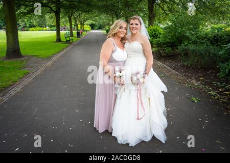 Braut und Brautjungfern haben Hochzeitsfotos in Floral Hall, Tunstall Park, Stoke on Trent, Hochzeitsfotos, Feiern, traditionelle englische Hochzeit Stockfoto